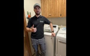 Appliance repair technician standing near laundry machines in Round Rock TX