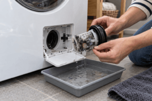 Homeowner removing lint from a front load washer drain pump filter Homeowner removing lint from a front load washer drain pump filter